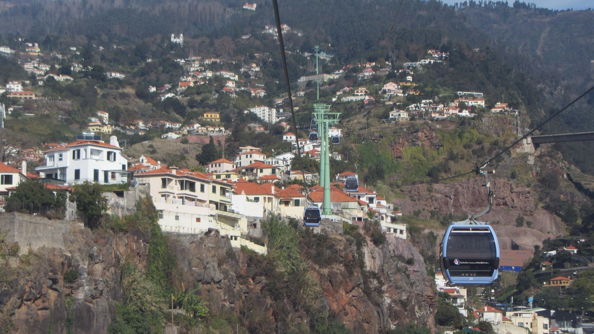 Cable car cabins above the hillside homes of Funchal
