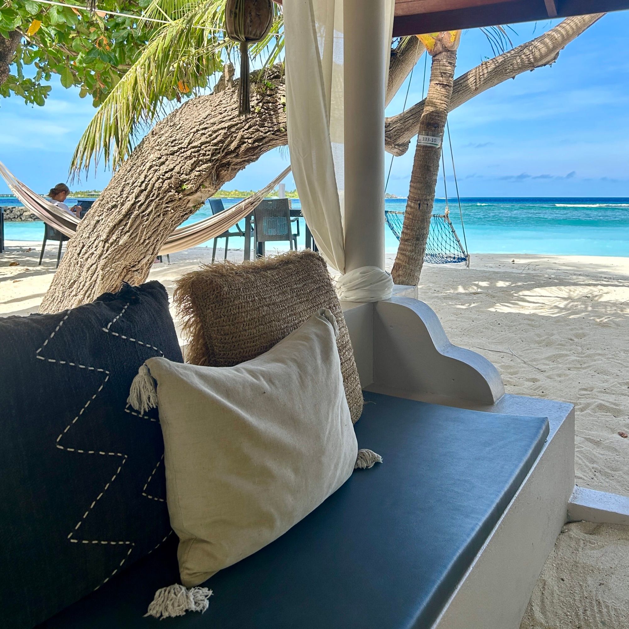 Shaded beach gazebo with cushions and hammock
