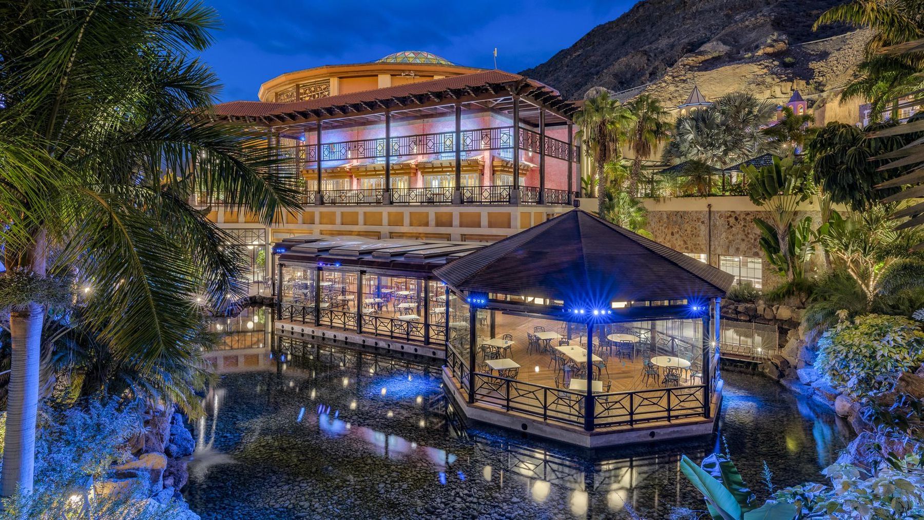 Garden pavilions and pond lit at dusk, Cordial Mogán Playa