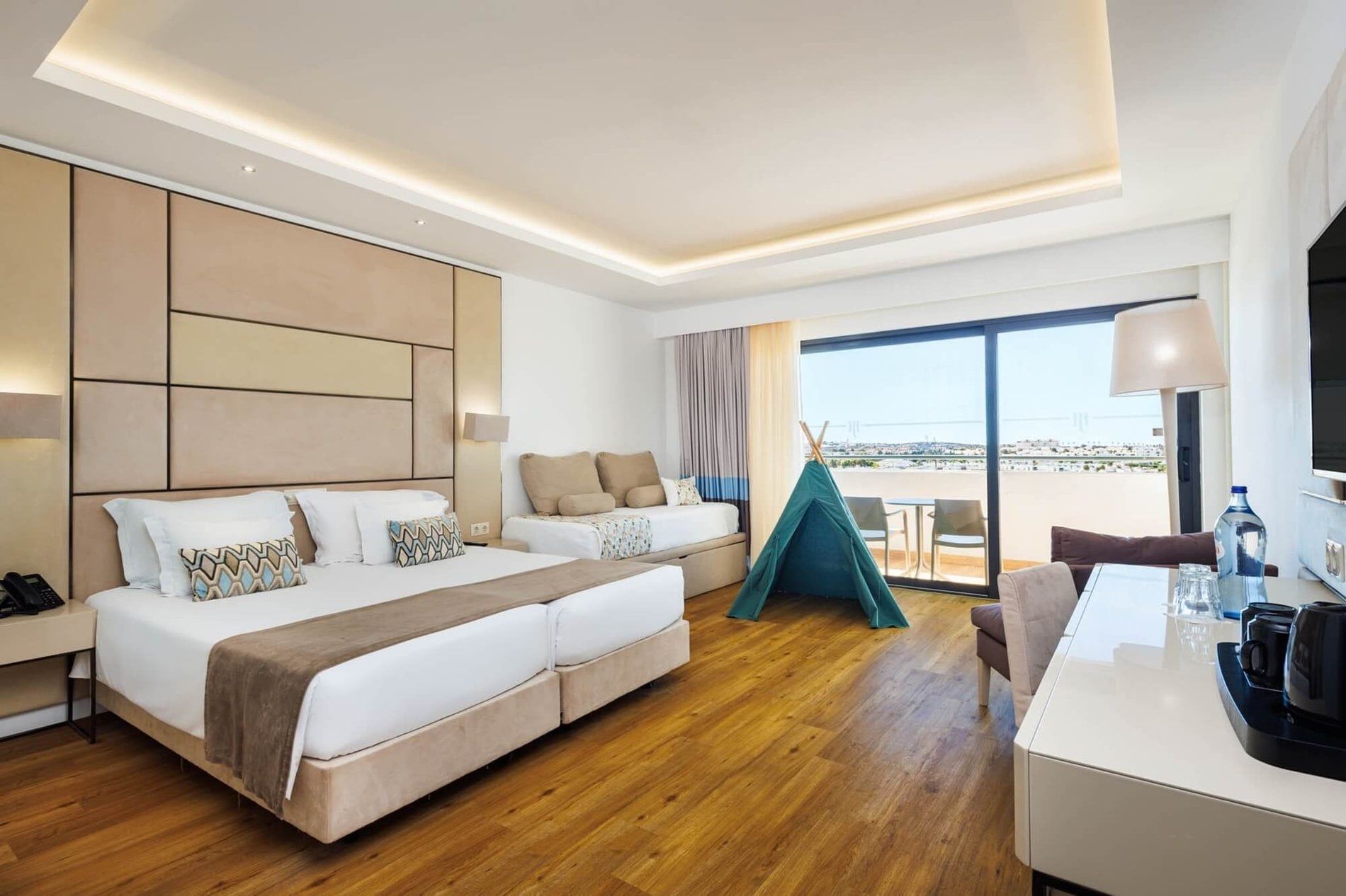 Family room with double and single beds and a balcony at Jupiter Albufeira