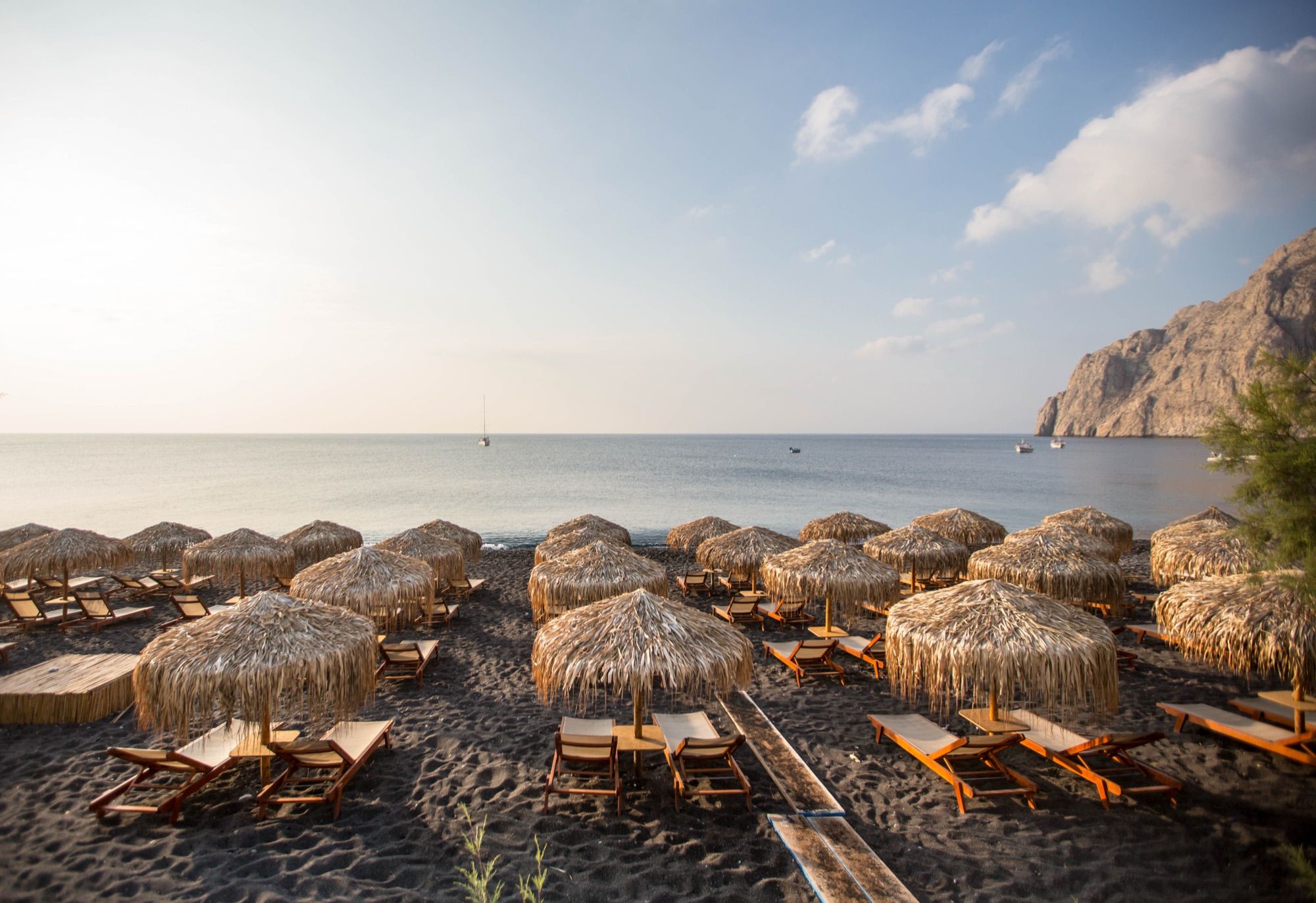 Sunbeds and umbrellas on Kamari's black-sand beach