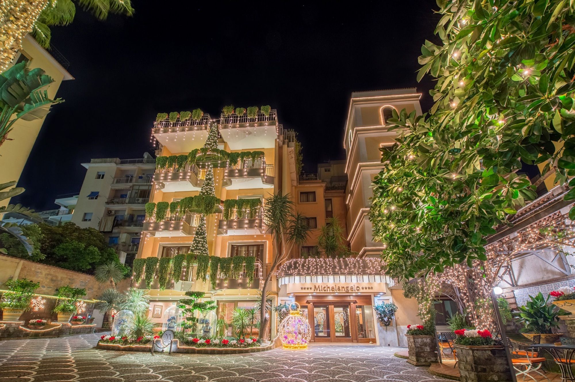 Hotel facade and garden entrance lit at night