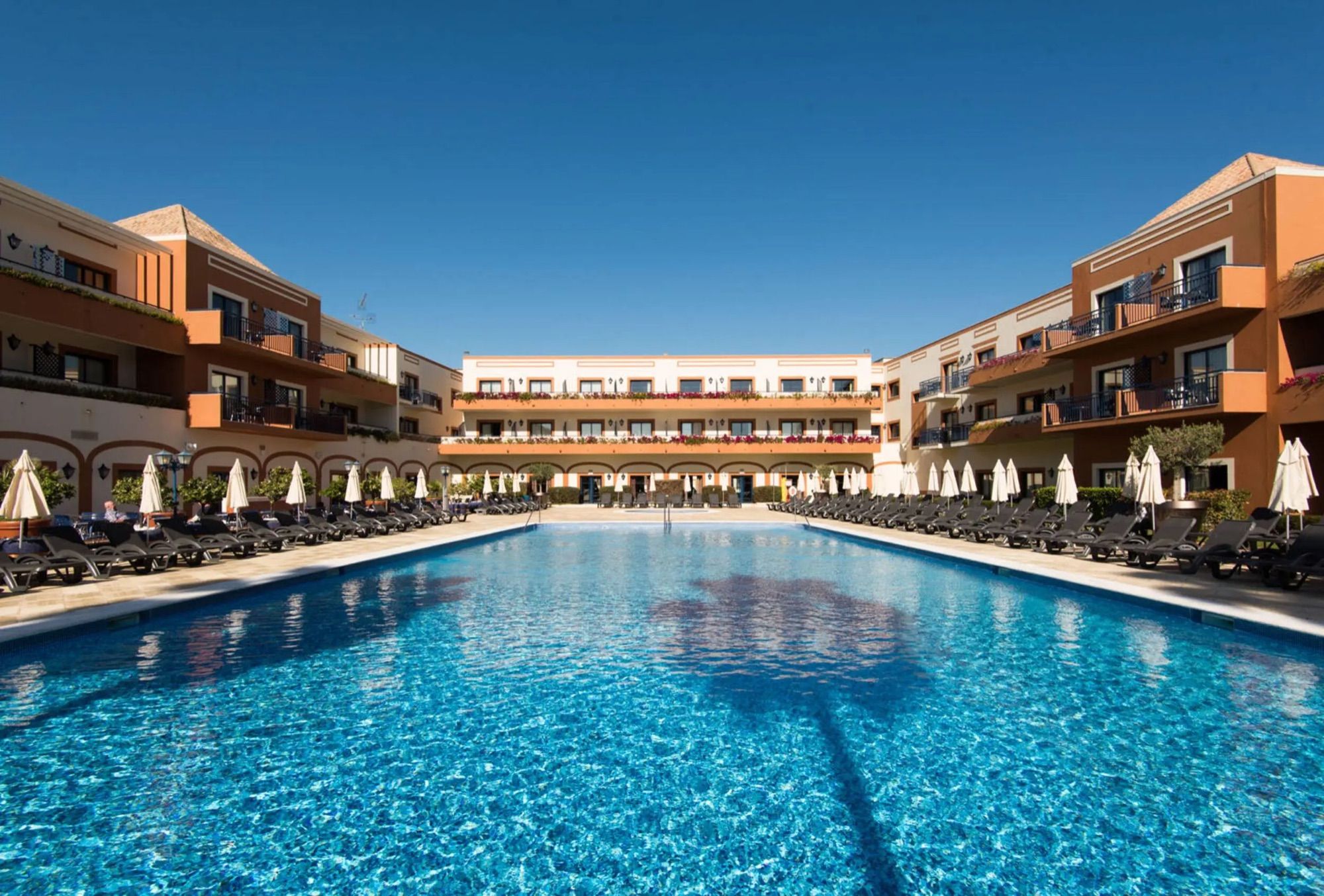 Large outdoor pool surrounded by the hotel wings of Vila Galé Tavira