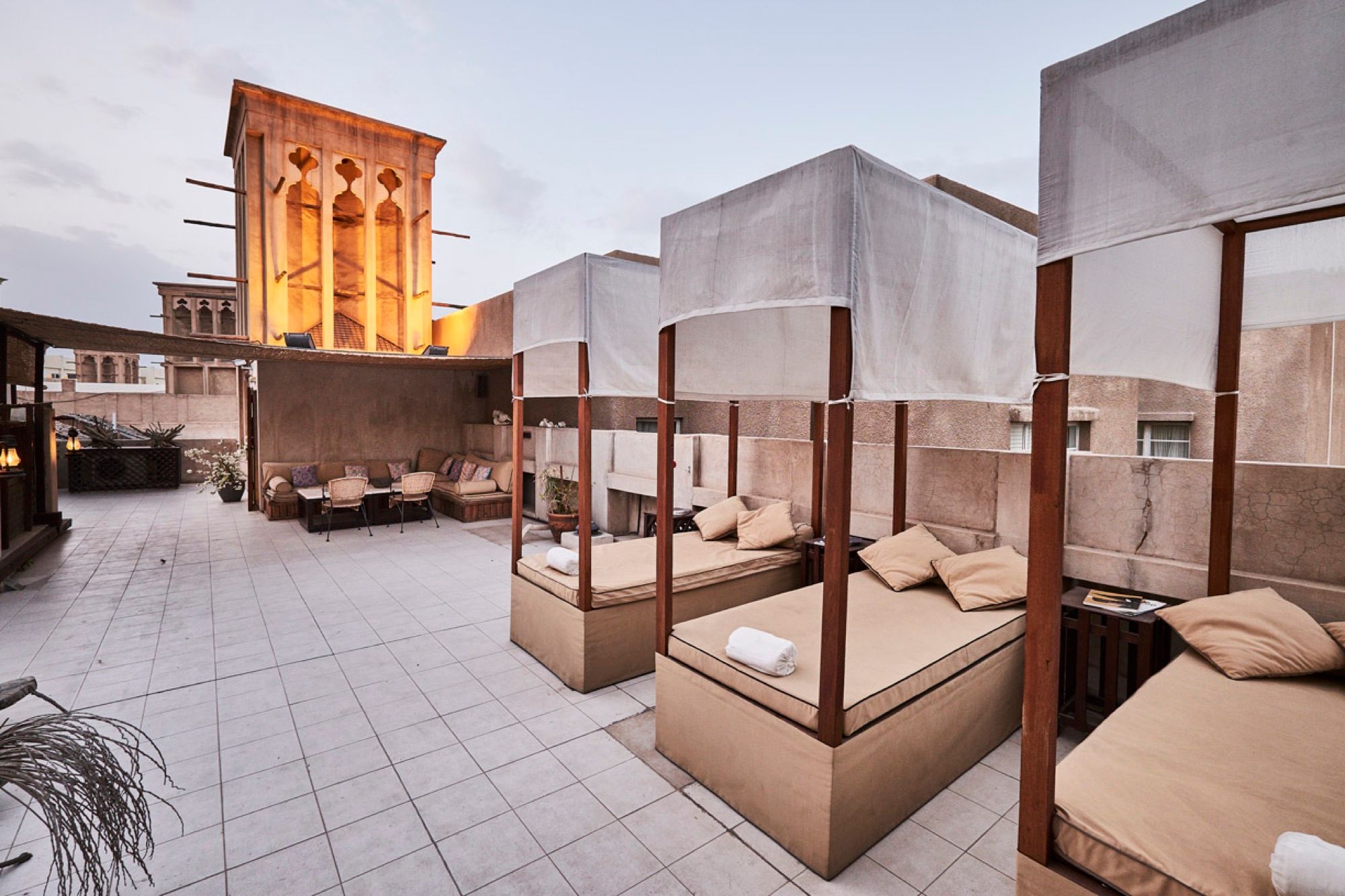 Roof terrace with canopied day beds and a wind tower at XVA Art Hotel
