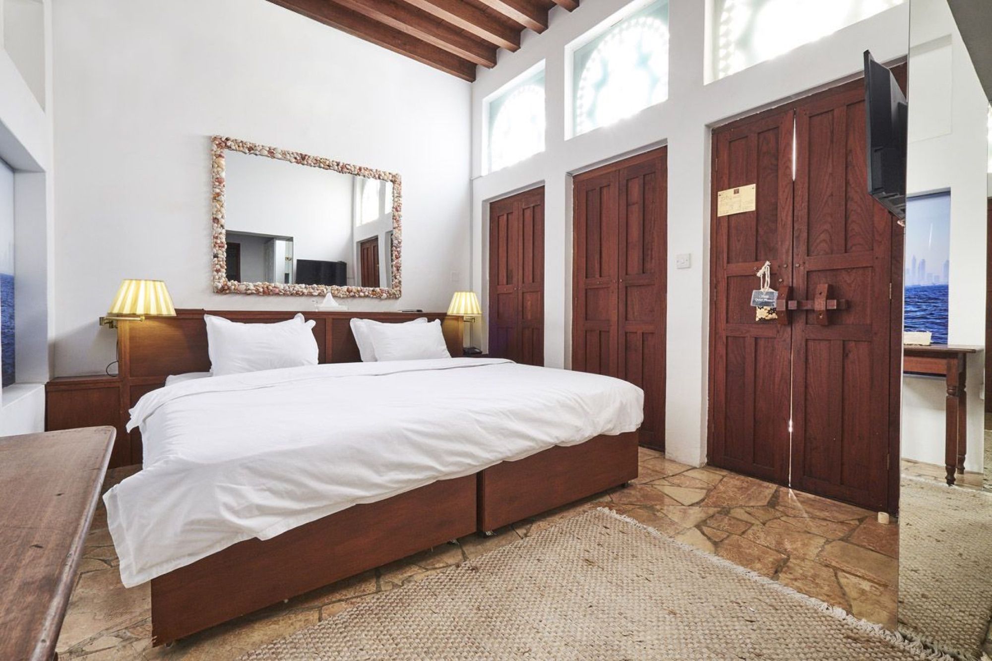 Room with wooden doors and a large mirror at XVA Art Hotel