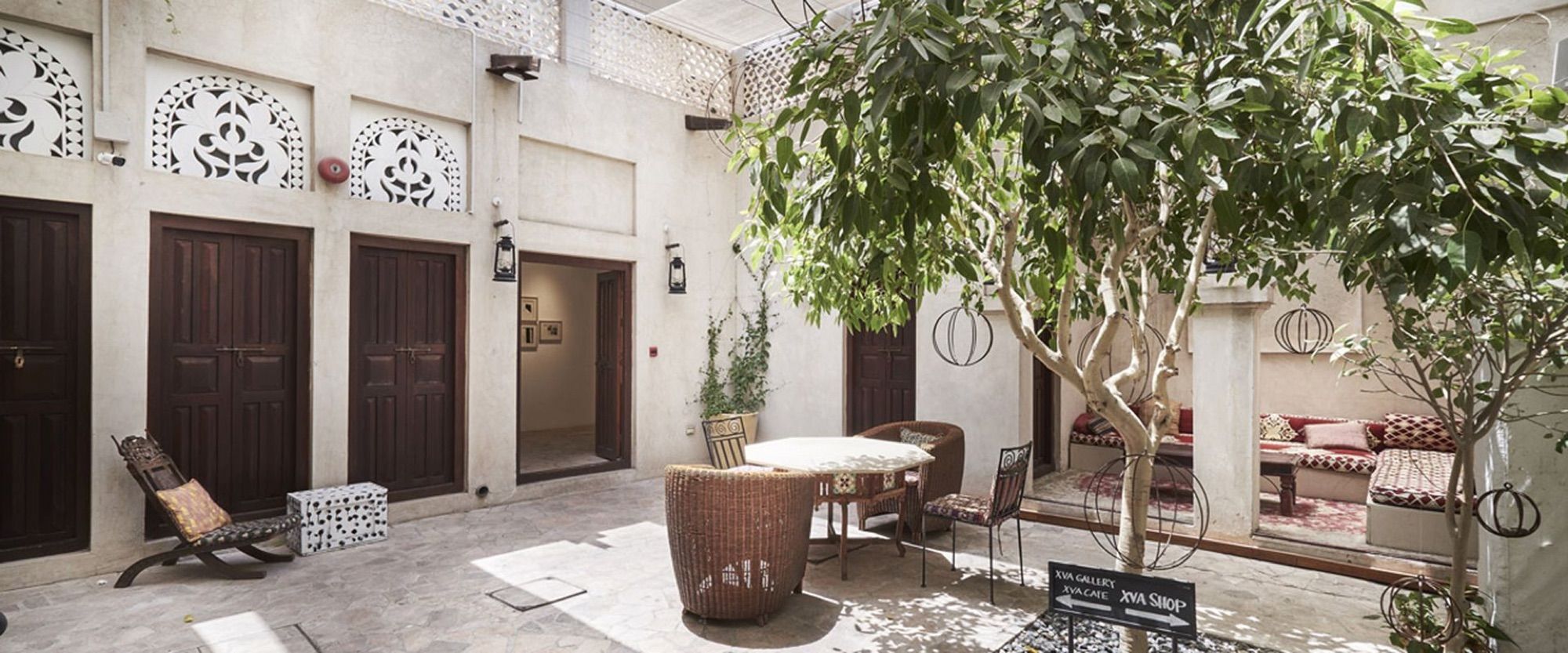 Courtyard with rooms and a tree at XVA Art Hotel