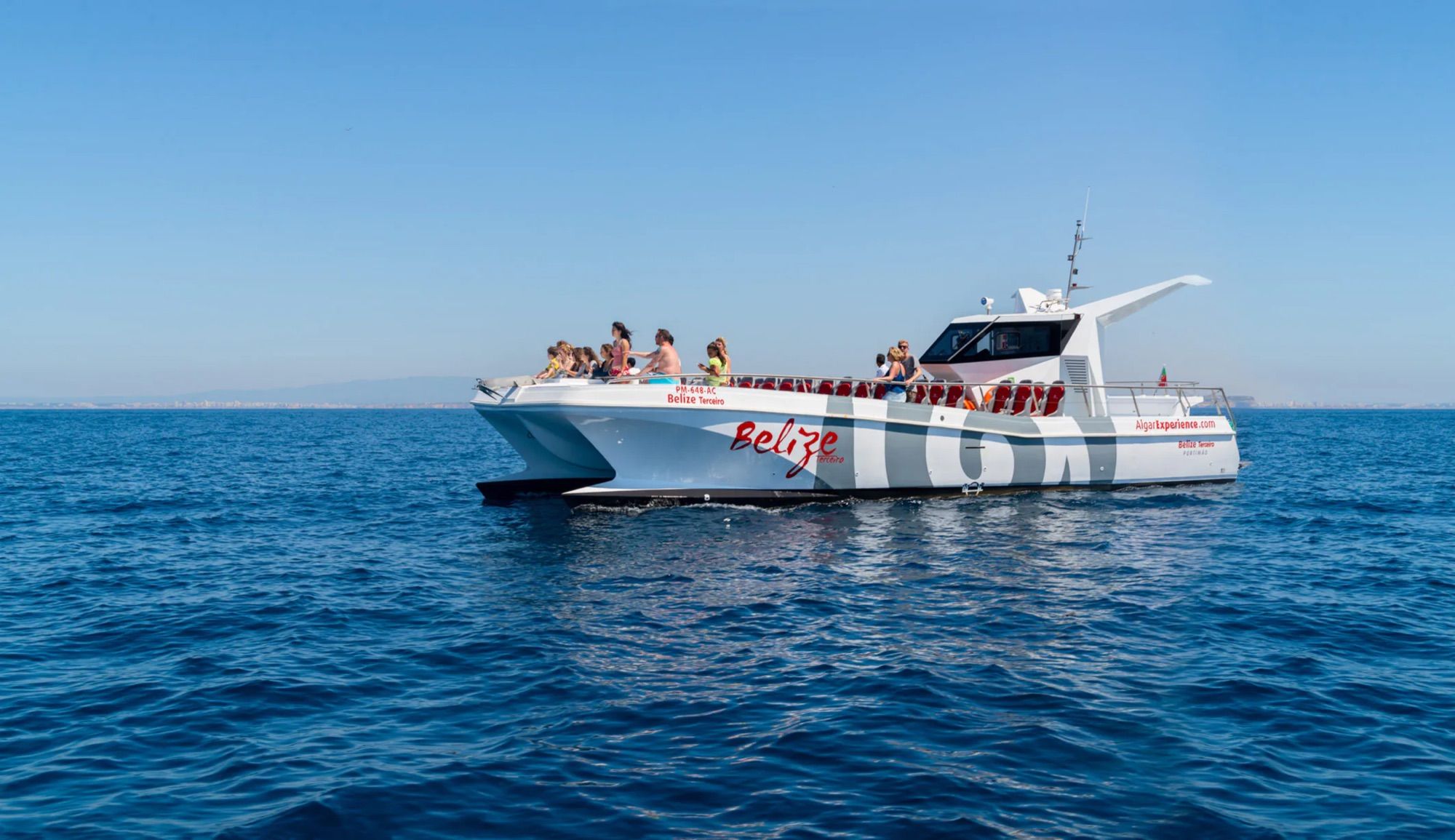 Catamaran with passengers on a calm blue sea