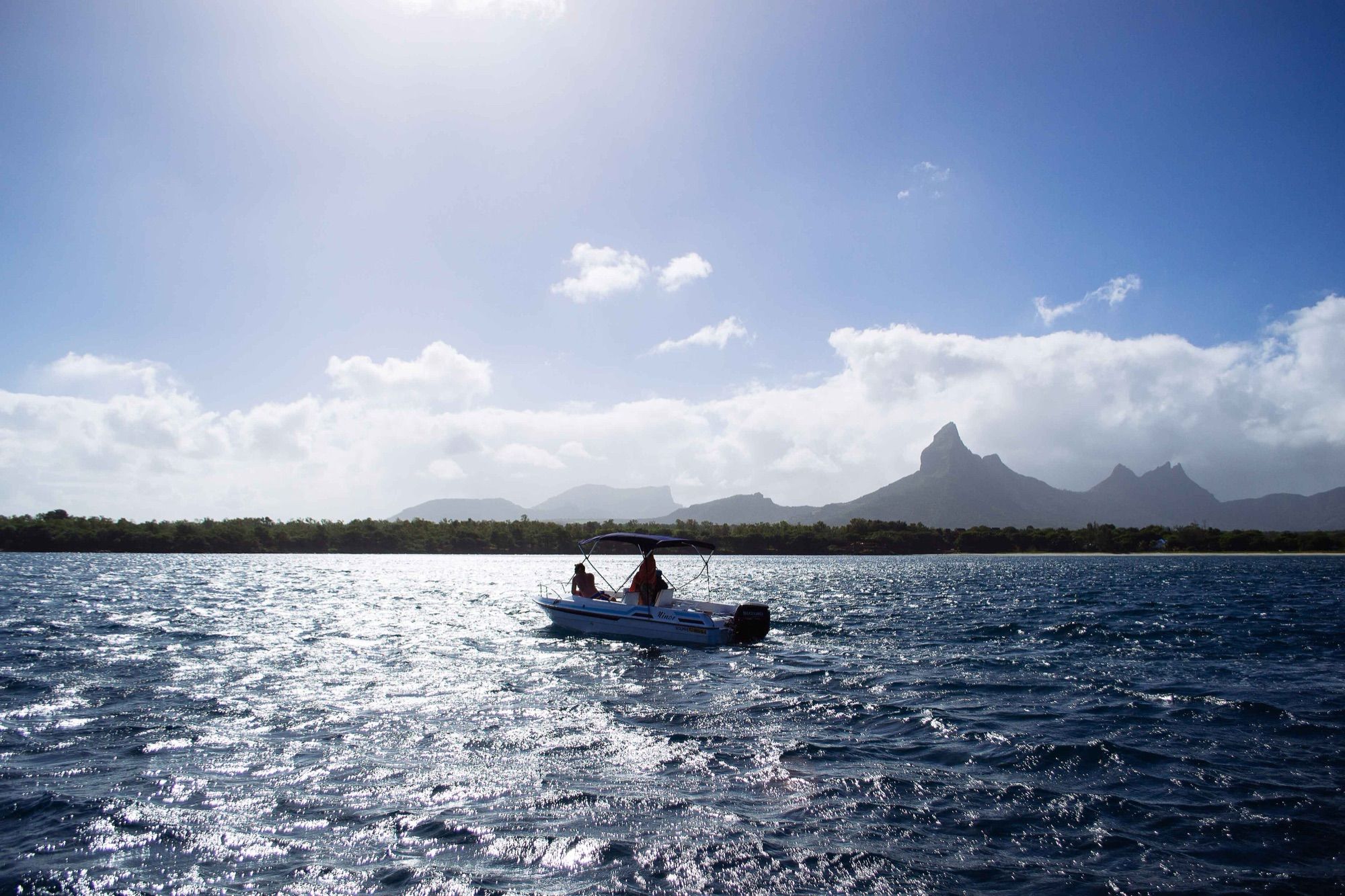 Small boat in Tamarin Bay with the west-coast mountains behind